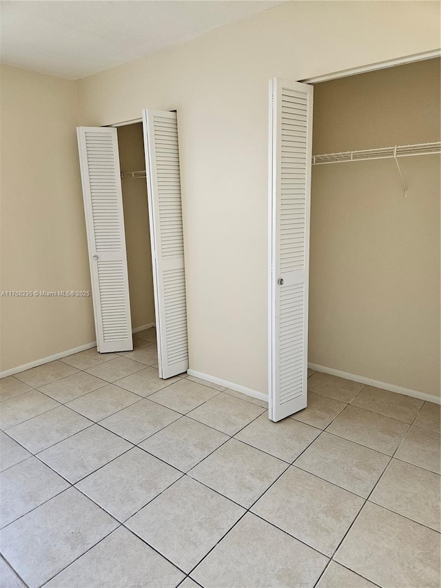 250 Layne Blvd Unit 105, Hallandale Beach, FL 33009 - unfurnished bedroom with light tile patterned flooring, baseboards, and a closet