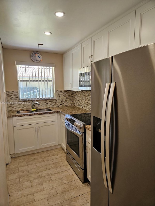 250 Layne Blvd Unit 105, Hallandale Beach, FL 33009 - kitchen with white cabinetry, a sink, stone counters, and appliances with stainless steel finishes