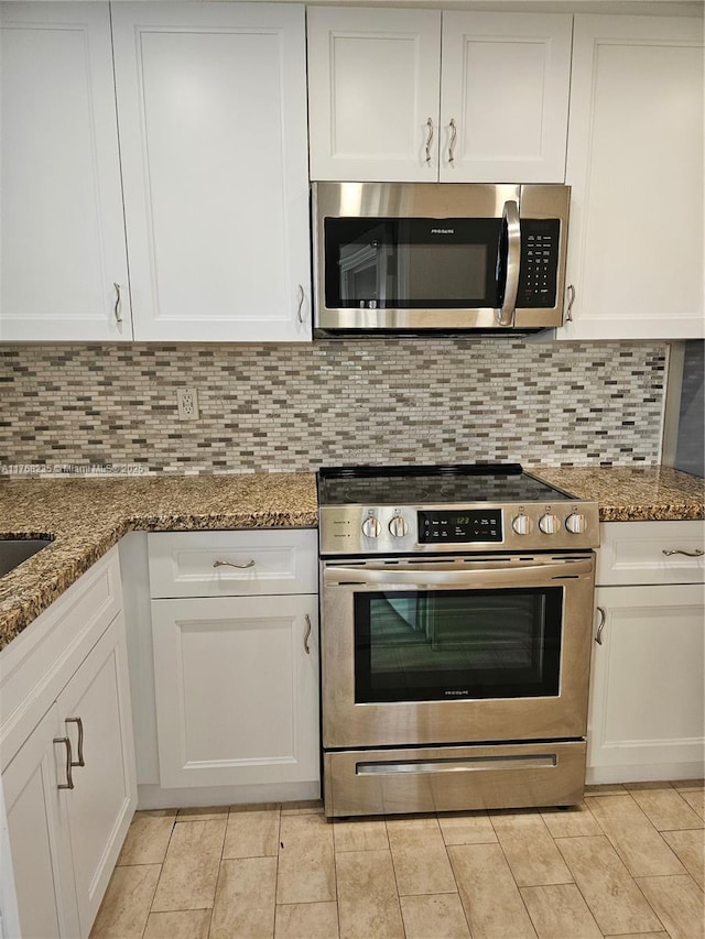 250 Layne Blvd Unit 105, Hallandale Beach, FL 33009 - kitchen with tasteful backsplash, light tile patterned floors, stainless steel appliances, stone countertops, and white cabinets