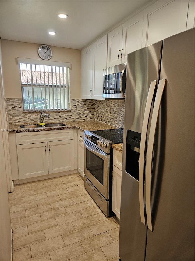 250 Layne Blvd Unit 105, Hallandale Beach, FL 33009 - kitchen with white cabinetry, a sink, stone counters, and appliances with stainless steel finishes