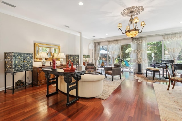 living area with decorative columns, a chandelier, dark wood-style flooring, ornamental molding, and recessed lighting