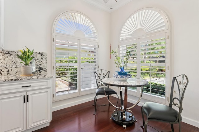 dining room with crown molding, dark wood-type flooring, baseboards, and plenty of natural light