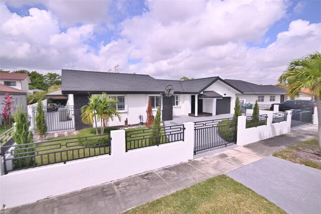 30 SW 136th Ave, Miami, FL 33184 - view of front facade with stucco siding, an attached garage, and a fenced front yard