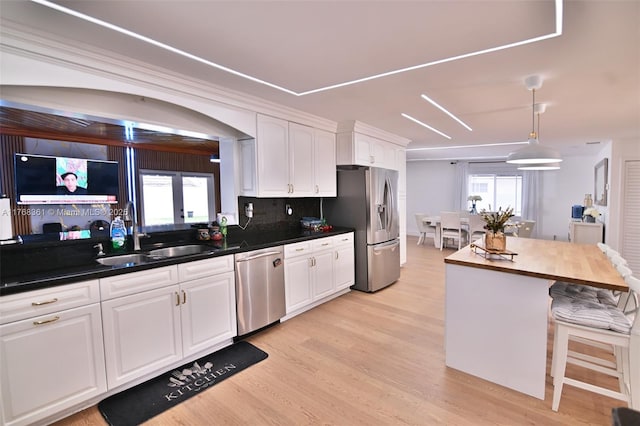 30 SW 136th Ave, Miami, FL 33184 - kitchen featuring decorative backsplash, white cabinets, light wood finished floors, appliances with stainless steel finishes, and decorative light fixtures
