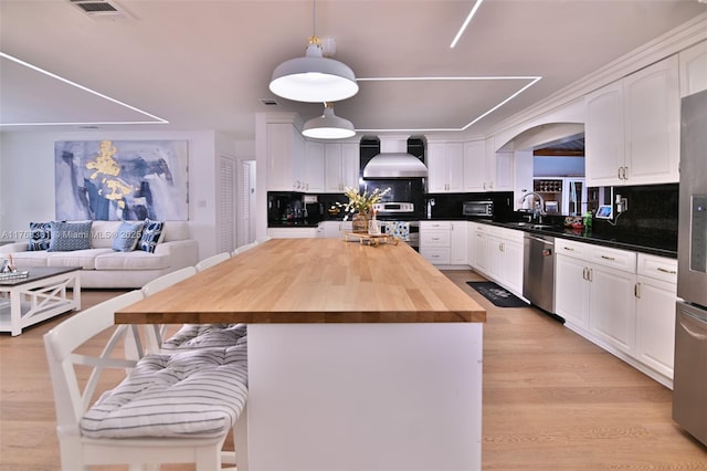 30 SW 136th Ave, Miami, FL 33184 - kitchen featuring tasteful backsplash, wooden counters, stainless steel appliances, wall chimney range hood, and visible vents
