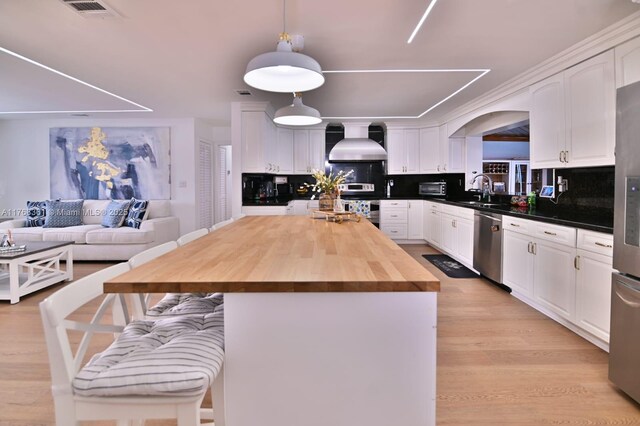 30 SW 136th Ave, Miami, FL 33184 - kitchen featuring visible vents, a breakfast bar, stainless steel appliances, wall chimney range hood, and backsplash
