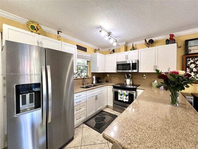 1203 Madrid St, Coral Gables, FL 33134 - kitchen with ornamental molding, a sink, appliances with stainless steel finishes, white cabinets, and light tile patterned floors