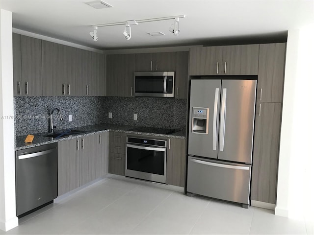 5350 NW 84th Ave Unit 1814, Doral, FL 33166 - kitchen featuring visible vents, a sink, dark stone countertops, backsplash, and stainless steel appliances