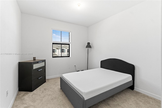 bedroom with light carpet and baseboards
