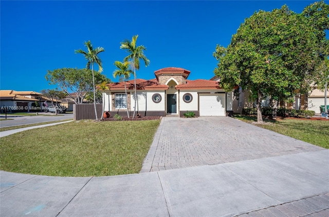 view of front facade featuring stucco siding, decorative driveway, an attached garage, a front yard, and a tiled roof