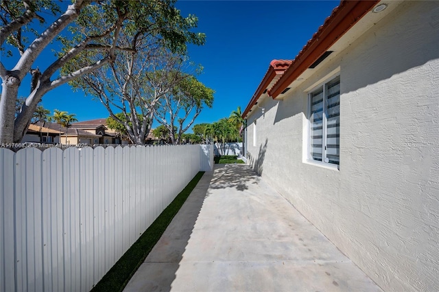 view of property exterior with stucco siding, a patio, and a fenced backyard