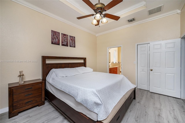 bedroom featuring light wood-type flooring, visible vents, a closet, and ornamental molding