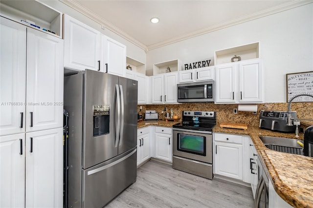 kitchen featuring stainless steel appliances, tasteful backsplash, ornamental molding, and white cabinets