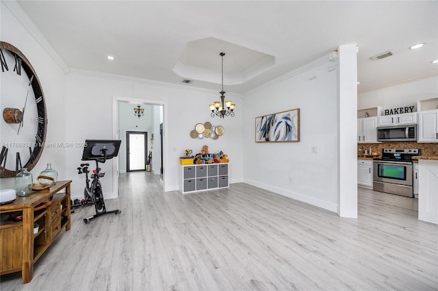 interior space with visible vents, light wood-style floors, ornamental molding, and a notable chandelier