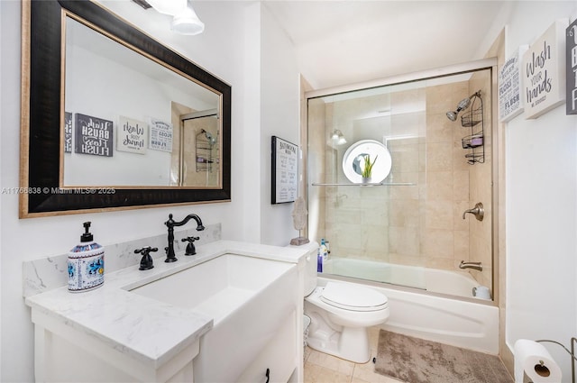 bathroom with tile patterned flooring, toilet, vanity, and shower / bath combination with glass door
