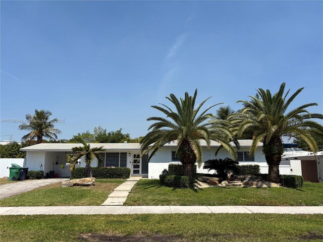 9545 SW 181st Ter, Palmetto Bay, FL 33157 - view of front facade featuring stucco siding, driveway, a front lawn, and fence