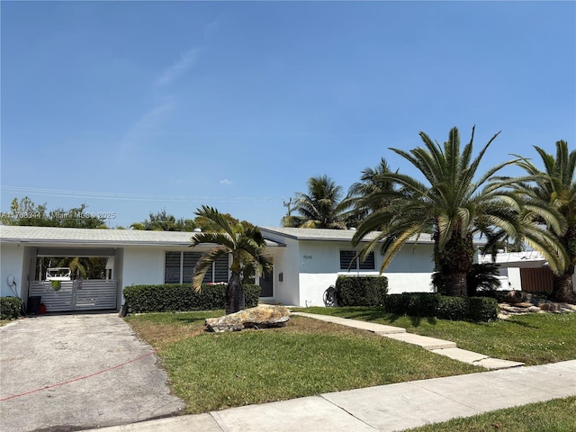 9545 SW 181st Ter, Palmetto Bay, FL 33157 - ranch-style house featuring stucco siding, driveway, a front lawn, and an attached carport