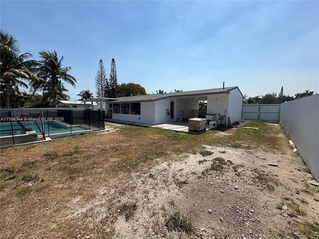9545 SW 181st Ter, Palmetto Bay, FL 33157 - back of house with a fenced in pool, a fenced backyard, stucco siding, a patio area, and a lawn