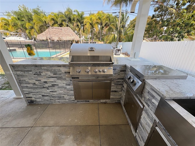 9545 SW 181st Ter, Palmetto Bay, FL 33157 - view of patio with grilling area, an outdoor kitchen, a fenced in pool, and a fenced backyard