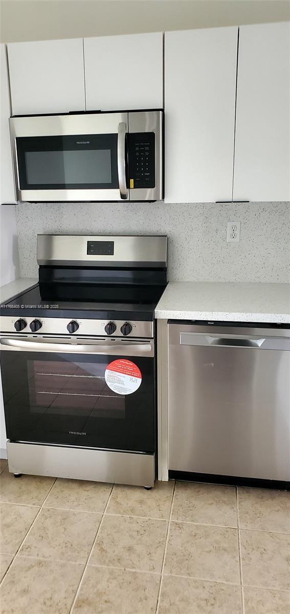 kitchen with white cabinets, appliances with stainless steel finishes, and light countertops