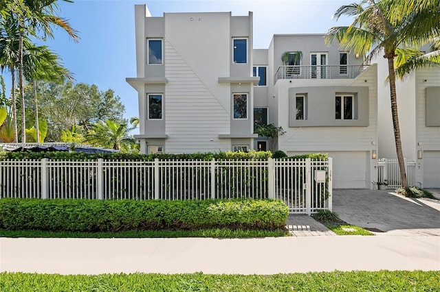 306 NE 8th Ave Unit 306, Fort Lauderdale, FL 33301 - view of front of house featuring stucco siding, a garage, driveway, and a fenced front yard