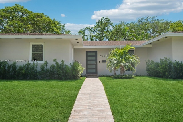 7640 SW 165th Ter, Palmetto Bay, FL 33157 - doorway to property featuring a lawn and stucco siding