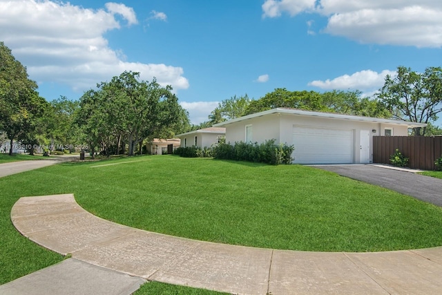 7640 SW 165th Ter, Palmetto Bay, FL 33157 - view of home's exterior with aphalt driveway, fence, an attached garage, a lawn, and stucco siding