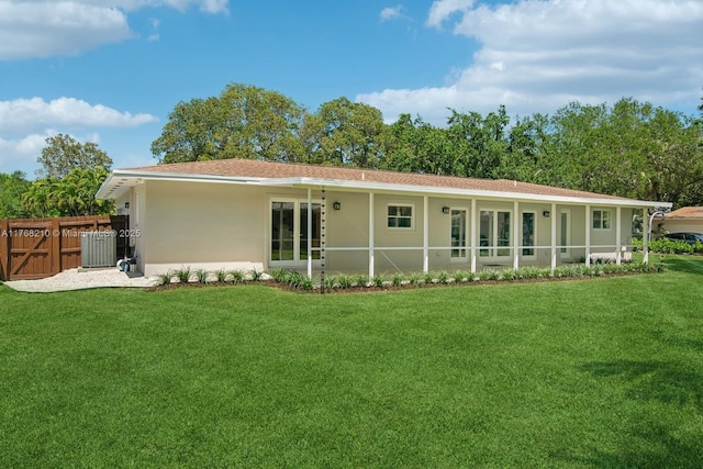 7640 SW 165th Ter, Palmetto Bay, FL 33157 - back of house featuring central AC unit, stucco siding, fence, and a lawn