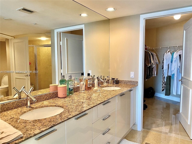 18911 Collins Ave Unit 2003, Sunny Isles Beach, FL 33160 - bathroom with a shower stall, double vanity, a walk in closet, toilet, and recessed lighting