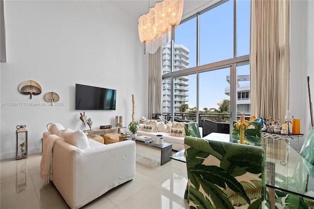 living area featuring a chandelier, tile patterned flooring, a towering ceiling, and a wealth of natural light