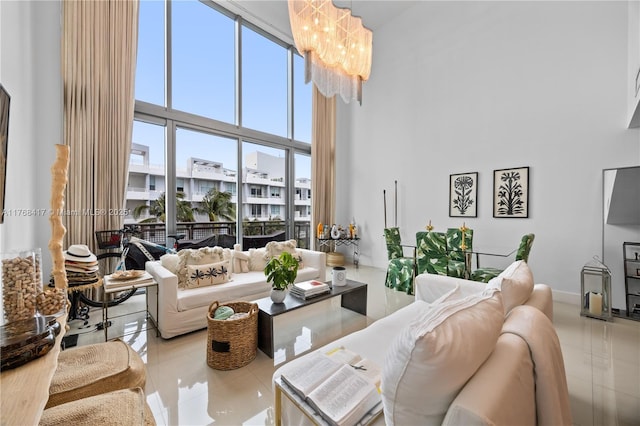 tiled living room featuring a high ceiling and an inviting chandelier