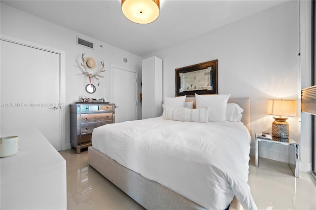bedroom featuring light tile patterned floors and visible vents