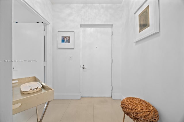 interior space with light tile patterned floors and baseboards