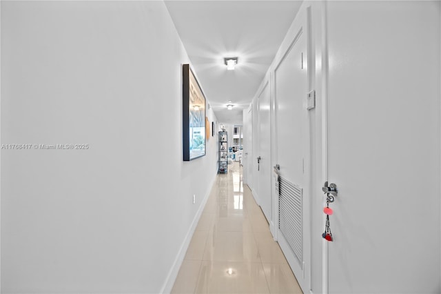 corridor with light tile patterned floors, baseboards, and visible vents