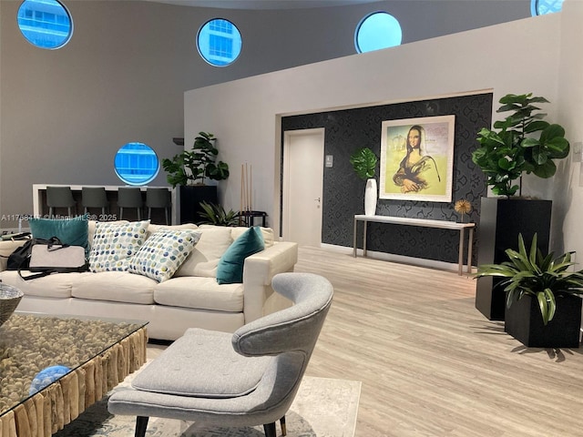 living area with baseboards, a high ceiling, and wood finished floors