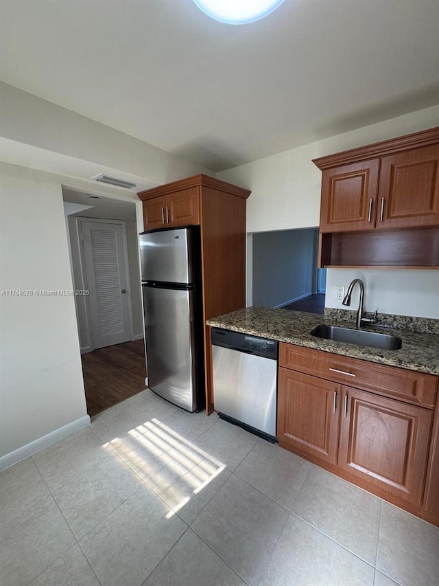 1201 NE 191st St Unit G313, Miami, FL 33179 - kitchen featuring dark stone countertops, light tile patterned floors, baseboards, a sink, and stainless steel appliances