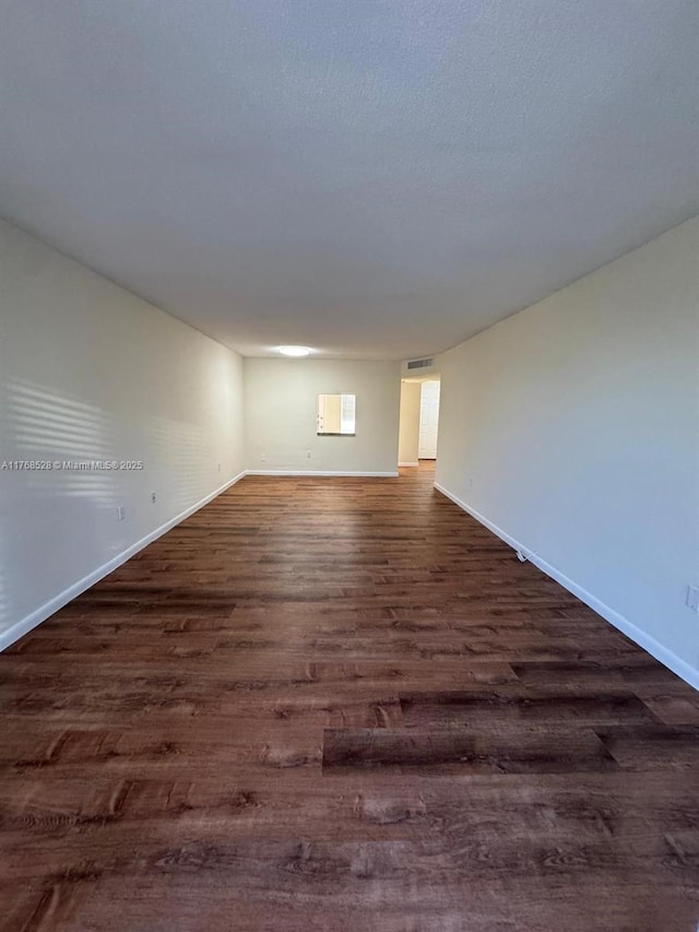 1201 NE 191st St Unit G313, Miami, FL 33179 - unfurnished room featuring visible vents, baseboards, a textured ceiling, and dark wood-style flooring