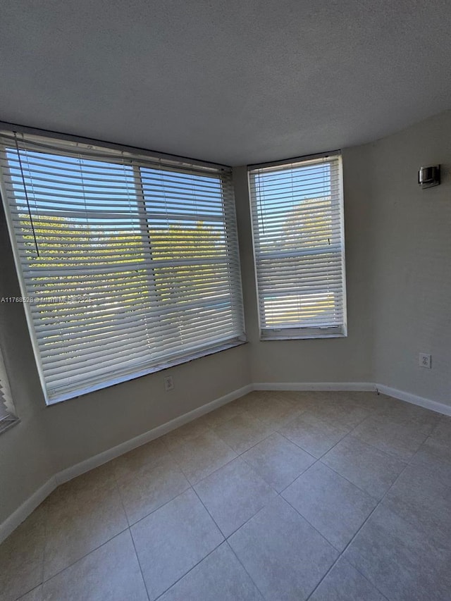 1201 NE 191st St Unit G313, Miami, FL 33179 - tiled empty room with a textured ceiling and baseboards