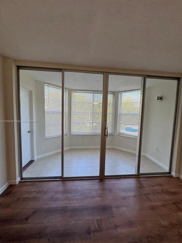 1201 NE 191st St Unit G313, Miami, FL 33179 - interior space featuring baseboards, a textured ceiling, and wood finished floors