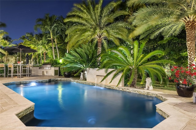 outdoor pool featuring area for grilling, fence, and a patio