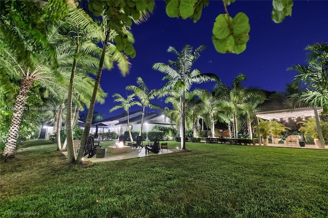 yard at night featuring a patio area