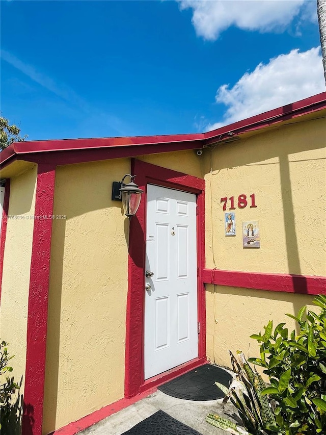 view of exterior entry with stucco siding