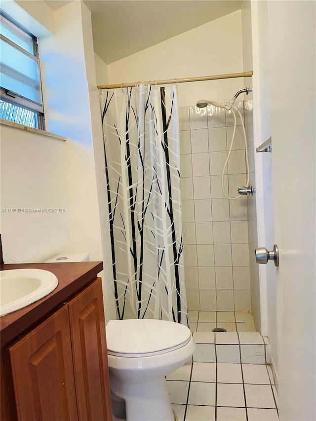 full bathroom with tile patterned floors, tiled shower, toilet, and vanity