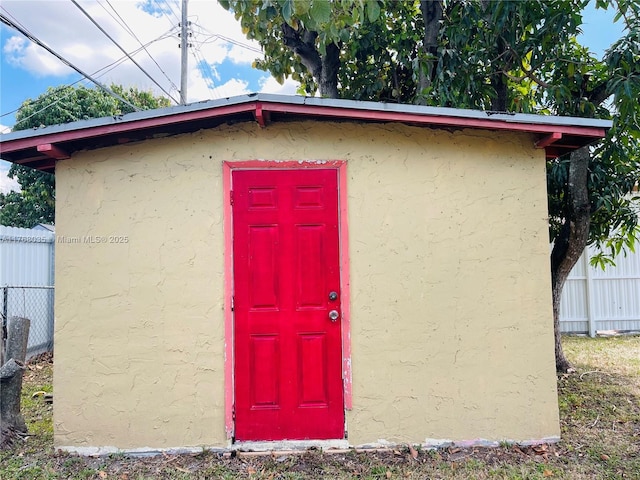 view of outdoor structure featuring an outbuilding and fence