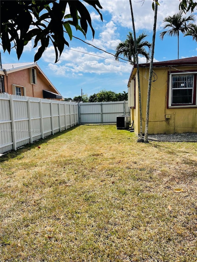 view of yard featuring central AC unit and a fenced backyard