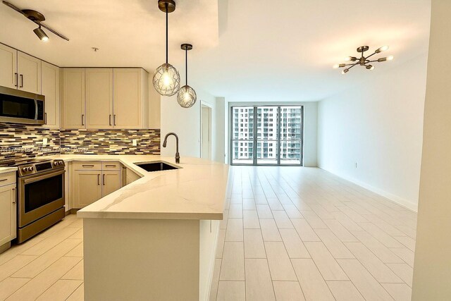 801 Brickell Key Blvd Unit 908, Miami, FL 33131 - kitchen featuring appliances with stainless steel finishes, a sink, a peninsula, backsplash, and open floor plan
