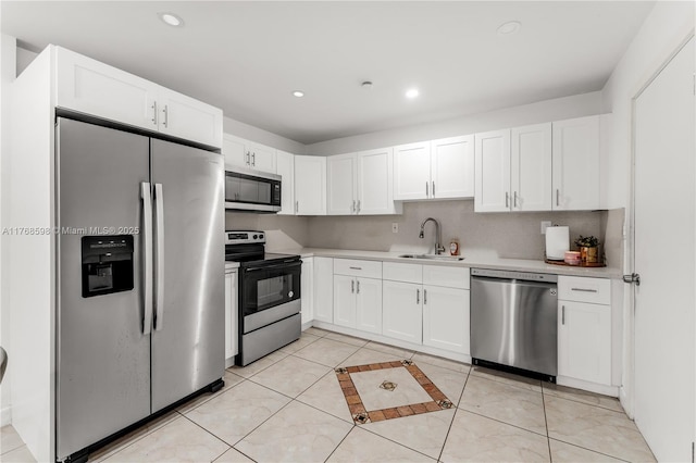 kitchen featuring light countertops, recessed lighting, appliances with stainless steel finishes, white cabinets, and a sink