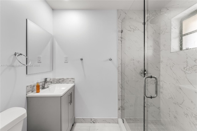 bathroom featuring a marble finish shower, toilet, vanity, and backsplash