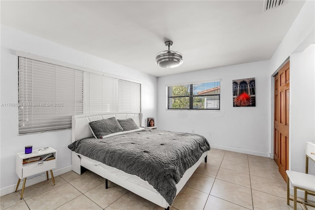 bedroom featuring light tile patterned floors, baseboards, and visible vents