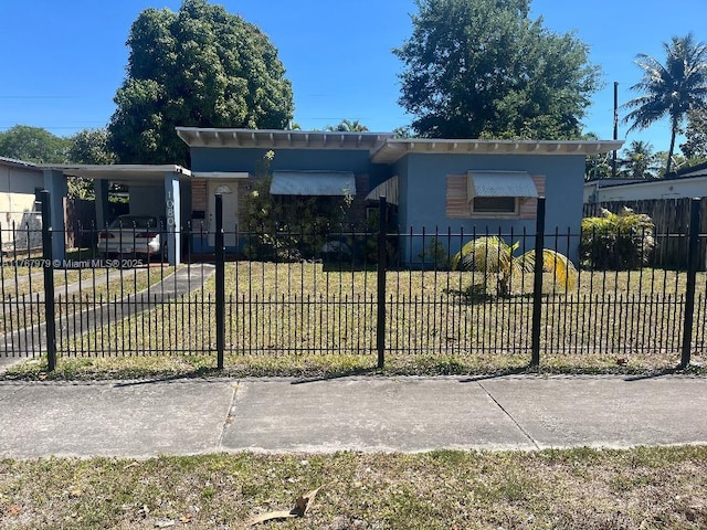 view of front of home featuring a carport, stucco siding, a front yard, and a fenced front yard